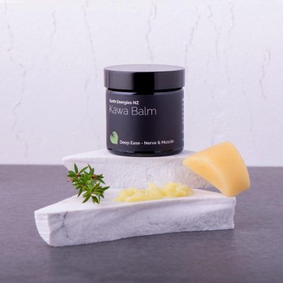 Kawakawa Balm product photographed with natural ingredients surrounding it